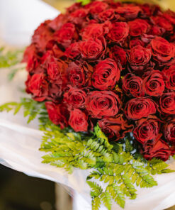 A bouquet of red roses with a ferns